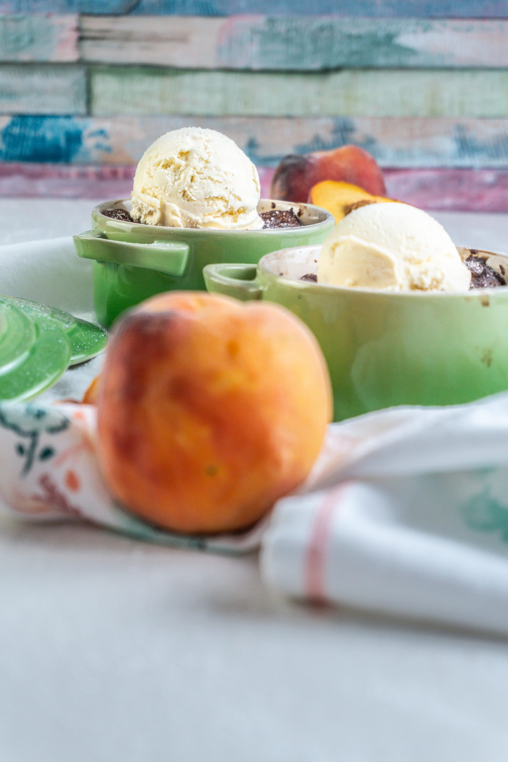 Mini Peach Cobbler in a ramekin dish with some ice cream on top and a second cobbler visible in the front